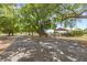 Long gravel driveway with covered parking area and mature trees at 7823 Baron Ave, Howey In The Hills, FL 34737