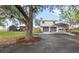 Home's exterior featuring a carport and a storage building on an expansive green lot at 7823 Baron Ave, Howey In The Hills, FL 34737