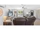 Spacious living room with a large window, natural light and comfortable leather couch at 7823 Baron Ave, Howey In The Hills, FL 34737