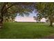 Expansive lawn area framed by mature trees under a pastel sky at 7823 Baron Ave, Howey In The Hills, FL 34737