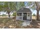 Exterior of backyard shed with porch and rocking chairs; landscaping and yard visible at 7823 Baron Ave, Howey In The Hills, FL 34737