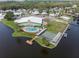 Aerial view highlighting the community clubhouse, pool, shuffleboard, and boat docks along the lake at 8 Cocos Plumosa Dr # A, Eustis, FL 32726