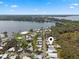 An aerial view showcases a mobile home community adjacent to a serene lake and lush trees at 8 Cocos Plumosa Dr # A, Eustis, FL 32726