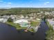 Aerial view showcasing a community clubhouse, pool, shuffleboard, boat docks and a bridge on the lake at 8 Cocos Plumosa Dr # A, Eustis, FL 32726