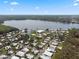 An aerial view of a charming mobile home community near a tranquil lake surrounded by lush trees at 8 Cocos Plumosa Dr # A, Eustis, FL 32726