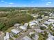 Wide aerial showcasing the community situated among trees, adjacent homes, and roadways at 8 Cocos Plumosa Dr # A, Eustis, FL 32726