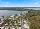 An aerial view of a mobile home community adjacent to a lake and lush trees under a partly cloudy sky at 8 Cocos Plumosa Dr # A, Eustis, FL 32726