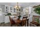 Bright dining room featuring a wood table, chandelier, and built-in cabinets for storage and display at 8 Cocos Plumosa Dr # A, Eustis, FL 32726
