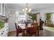 Charming dining room with a chandelier, wooden table set for four, and a view into the living area at 8 Cocos Plumosa Dr # A, Eustis, FL 32726