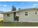 Side exterior showing the siding, windows, partial roof line, and covered back porch at 8 Cocos Plumosa Dr # A, Eustis, FL 32726