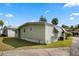 Exterior view of the property showing the light green siding, landscaping, and a paved driveway at 8 Cocos Plumosa Dr # A, Eustis, FL 32726