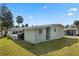 Rear exterior showing the siding, windows, partial roof line, and covered back porch with furniture at 8 Cocos Plumosa Dr # A, Eustis, FL 32726