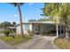 Single-story home with covered parking, lush greenery, and a welcoming entryway for easy access at 8 Cocos Plumosa Dr # A, Eustis, FL 32726