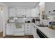 Charming kitchen with white appliances, cabinets, and window with stainless steel sink at 8 Cocos Plumosa Dr # A, Eustis, FL 32726