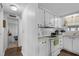 Clean kitchen features white appliances and cabinets with wood-look flooring at 8 Cocos Plumosa Dr # A, Eustis, FL 32726