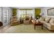 Bright living room with two plush armchairs, a comfortable sofa, and natural light from large windows at 8 Cocos Plumosa Dr # A, Eustis, FL 32726
