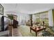 Warm living room featuring a sofa, recliners, TV, piano, and French doors to the outside at 8 Cocos Plumosa Dr # A, Eustis, FL 32726