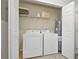 Laundry room equipped with a white washer and dryer and wire shelving at 9423 Myrtle Creek Ln # 510, Orlando, FL 32832