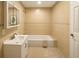 Bright, tiled bathroom features a combination bathtub and shower, and a large vanity mirror at 101 Dovetail Ct, Apopka, FL 32703