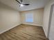 Clean, empty bedroom with wood-look flooring, ceiling fan, and ample natural light at 101 Dovetail Ct, Apopka, FL 32703