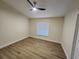 Clean, empty bedroom with wood-look flooring, ceiling fan, and ample natural light at 101 Dovetail Ct, Apopka, FL 32703