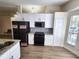 Modern kitchen with stainless steel appliances, white cabinets, and granite countertops at 101 Dovetail Ct, Apopka, FL 32703