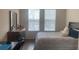 Bright bedroom with two windows, featuring a desk, dresser, and queen-sized bed at 11446 Jasper Kay Terrace # 202, Windermere, FL 34786