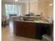 Efficient wet bar area with dark wood cabinets, granite countertops, stainless steel sink and black appliances at 11446 Jasper Kay Terrace # 202, Windermere, FL 34786