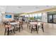 A clubhouse interior features tables, chairs, a TV, a kitchen, and large windows that overlook the beautiful community pool area at 1803 Perch Hammock Loop, Groveland, FL 34736