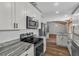 Modern kitchen featuring white cabinetry, granite countertops, and stainless steel appliances at 1831 W Clinton Dr, St Cloud, FL 34769