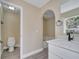Bright bathroom features a tub with an arch, a white vanity with modern sink and a toilet at 2004 Prescott Blvd, Deltona, FL 32738