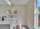 Modern bathroom features a double sink vanity, gray floors, and natural light from the window at 2004 Prescott Blvd, Deltona, FL 32738