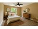 Bedroom decorated with wooden dresser, circular mirror, queen bed, and side tables with lamps at 2004 Prescott Blvd, Deltona, FL 32738