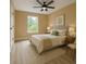 A serene bedroom featuring a ceiling fan, a large window, and neutral decor with two side tables at 2004 Prescott Blvd, Deltona, FL 32738