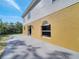 Exterior view of the home featuring a concrete patio, sliding glass door, and arched window at 2004 Prescott Blvd, Deltona, FL 32738