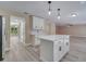 Bright kitchen with gray wood-look floors, white cabinets, an island with pendant lights, and stainless steel appliances at 2004 Prescott Blvd, Deltona, FL 32738