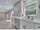 Bright kitchen with gray wood-look floors, white cabinets, quartz countertops, and stainless steel appliances at 2004 Prescott Blvd, Deltona, FL 32738