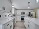 Bright kitchen with gray wood-look floors, white cabinets, an island with pendant lights, and stainless steel appliances at 2004 Prescott Blvd, Deltona, FL 32738