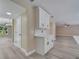 Bright kitchen with gray wood-look floors, white cabinets, an island with pendant lights, and stainless steel appliances at 2004 Prescott Blvd, Deltona, FL 32738