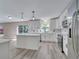 Bright kitchen with gray wood-look floors, white cabinets, quartz countertops, and stainless steel appliances at 2004 Prescott Blvd, Deltona, FL 32738