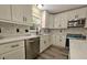 Updated kitchen features white cabinets, stainless appliances, updated backsplash and modern fixtures and hardware at 2004 Prescott Blvd, Deltona, FL 32738