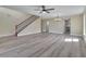 A spacious living room with new gray floors, natural light, and staircase with ironwork at 2004 Prescott Blvd, Deltona, FL 32738