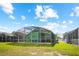 Spacious backyard with screened-in pool area and lush green lawn at 202 Aylesbury Ln, Davenport, FL 33837