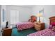 Bright bedroom with two twin beds and coordinated floral bedding at 202 Aylesbury Ln, Davenport, FL 33837