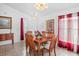 Traditional dining room featuring a wood table set with red curtains and white walls at 202 Aylesbury Ln, Davenport, FL 33837