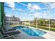 Inviting screened-in pool with clear blue water and poolside lounge chairs, perfect for relaxation and entertainment at 202 Aylesbury Ln, Davenport, FL 33837