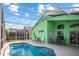 Lovely pool area with lounge chairs and an outdoor table, enclosed by a screened patio for comfortable outdoor living at 202 Aylesbury Ln, Davenport, FL 33837