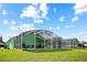 Spacious backyard with a screened-in porch, lush green lawn, and ample seating, perfect for outdoor gatherings at 202 Aylesbury Ln, Davenport, FL 33837