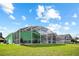 Expansive backyard featuring a screened-in porch, well-maintained lawn, and comfortable seating under a bright sky at 202 Aylesbury Ln, Davenport, FL 33837