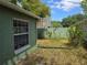Backyard of house with window and view of neighbors house through the green fence at 209 Silas Phelps W Ct, Orlando, FL 32828